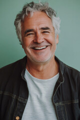 Candid smiling senior Caucasian man, grey hair and joyful smile, a soft pastel green background, creating a warm and inviting social media avatar.