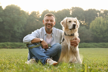 Wall Mural - Smiling man with cute Golden Retriever dog on spring day