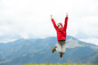 © New Africa - Happy young hiker jumping in mountains, low angle view. Space for text