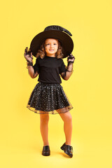 Canvas Print - Cute girl dressed like witch on yellow background. Halloween costume