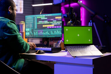 Aufkleber - Professional artist operating on daw software in home studio, using a greenscreen layout next to him. Producer editing his audio recordings by applying mixing and mastering techniques.