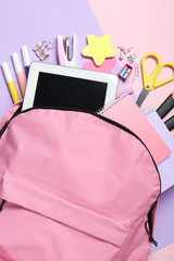 Poster - Backpack and different school stationery on pink background, flat lay