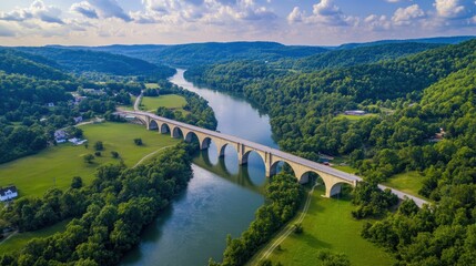 Canvas Print - Aerial view of a scenic bridge over a river surrounded by lush greenery.