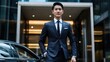 © Phoophinyo - An Asian businessman in a crisp suit stepping out of a luxury car in front of a corporate building, ready for a high-stakes business meeting