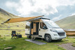 © Emanuel - Camper van with an awning extended, providing shade for outdoor relaxation