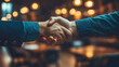 © Aino Minako - Two men shake hands in a business setting