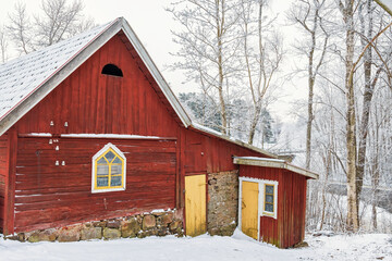 Canvas Print - Old red barn with a outhouse in a wintry landscape