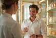 © natakot - A man testing a perfume at a stylish store, discussing the scent with a sales assistant. The scene captures a moment of curiosity and exploration in a refined environment.