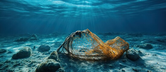 Plastic bag litter on the seabed with sunlight shining through the water.