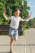 © Mariia - Beautiful little 8 years old girl jumping over the rope in the park on sunny summer day