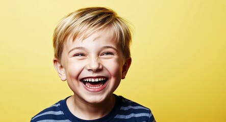 Kid white boy with bright smile and short blonde hair laughing soft yellow background