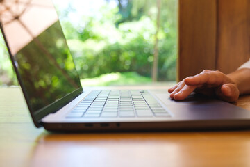 Wall Mural - Closeup image of a woman working and touching on laptop computer touchpad