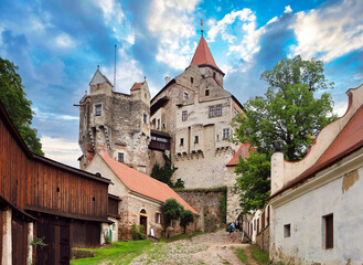 Pernstejn castle near the Nedvedice village, Czech Republic. Fairytale castle on hill during summer day. Big stone walls and towers.