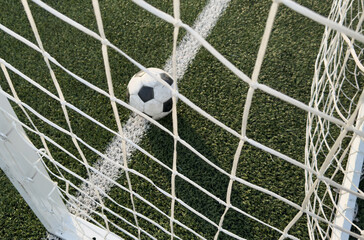 Soccer ball in goal on blue background