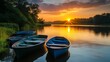 © Rstm - A serene scene of three boats moored on a lake at sunset with the sun glowing in the sky.
