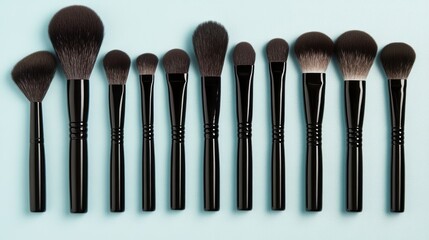 Assorted makeup brushes on soft blue background