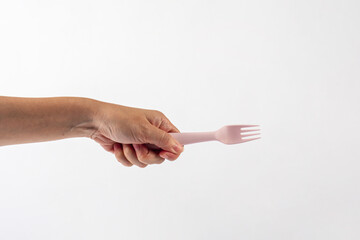 Wall Mural - Pink fork and hand isolated on white background.