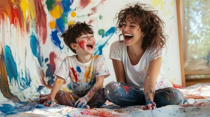 a joyful mother and son share a playful moment, covered in paint, surrounded by vibrant colors on a 