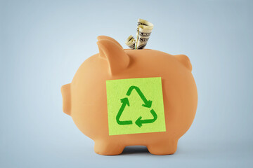 Piggy bank with recycling symbol on sticky note - Concept of ecology and environmental savings