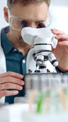 Man scientist with protective glasses using microscope in laboratory. Microbiology science concept