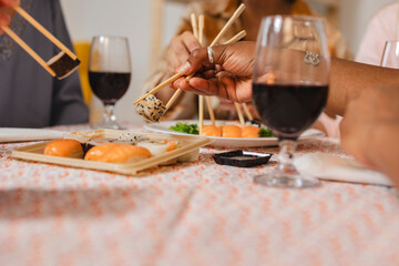 Friends enjoying christmas dinner with sushi and wine