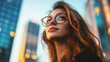 © GrayFrog - Portrait of young confident woman in glasses on a business district background