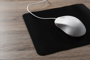 Sticker - Computer mouse with mousepad on wooden table, closeup