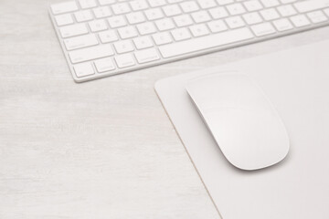 Sticker - Computer mouse with mousepad and keyboard on light wooden table, closeup. Space for text