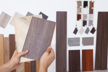 Wall Mural - Man with different samples of wooden flooring indoors, closeup