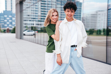 Canvas Print - Smiling beautiful woman and her handsome boyfriend. Couple in casual summer clothes. Happy cheerful family. Female and man having fun. They posing in the street in sunny day. Having tender moments