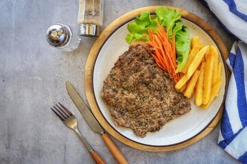 Pepper Pork Steak in white plate on grey background