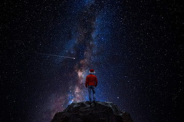 Wall Mural - hiker in santa hat watches shooting star in universe