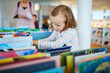 © Ekaterina Pokrovsky - Five year old girl selecting a book in municipal library