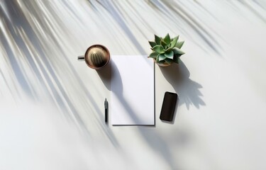 Aufkleber - A blank piece of paper, a pen, a cactus, and a smartphone are arranged on a white surface with soft, angled light and shadows.