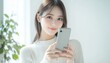 © kiewkoii - A closeup of a beautiful woman holding a smartphone