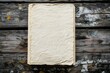 © mangolovemom - A blank, textured sheet of aged paper lies on a rustic wooden surface, showcasing a natural, vintage aesthetic.