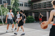 © qunica.com - A group of friends playing basketball on an old outdoor court in their neighborhood, showcasing camaraderie and active lifestyle in an urban setting.