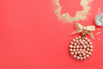 Canvas Print - Christmas ball made with blush and glitter on red background, top view. Space for text