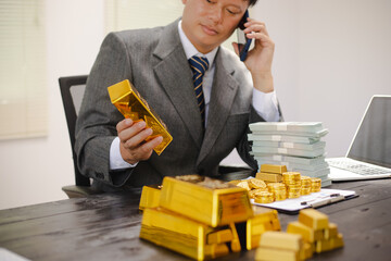 Businessman working hard with gold bars, assessing investments and transactions in finance office, wealth, asset allocation and precious metals trading strategies.