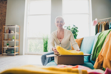 Poster - Photo of attractive charming woman dressed white cardigan putting clothes in box relocation apartment indoors