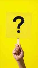 Poster - Hand holding a bright yellow sign with a bold black question mark symbolizing doubt and curiosity. Evokes inquiry and uncertainty, prompting thoughts about problems and solutions