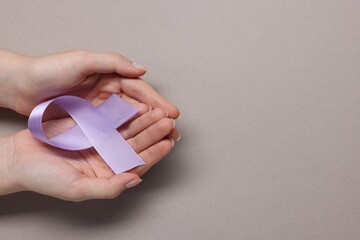 Canvas Print - Woman with violet ribbon on grey background, top view with space for text. Alzheimer disease, epilepsy and pancreas cancer awareness