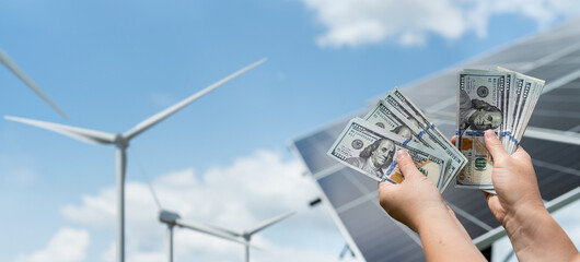 Poster - hand counting dollar after saving with solar panels and wind turbines generating electricity