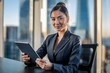 © Elathi - Asian businesswoman using digital tablet in the office with skyscraper background