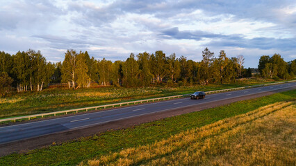 A truck and cars are driving along a beautiful road