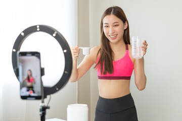 Vlogger asian young woman blogger, influencer showing product of health care, using smart mobile phone live selling food replacement, weight lose. Show goods to customer, present, streaming online.