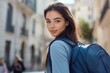 © Fotograf - A woman walking down a city street carrying a blue backpack, ideal for use in travel or adventure related projects