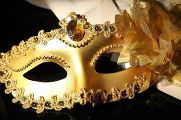 Sticker - Beautiful golden carnival mask on black background, closeup