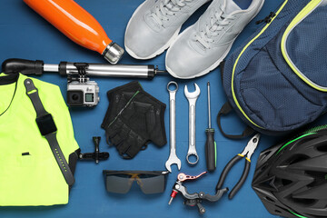 Poster - Bicycle accessories and tools on blue wooden background, flat lay