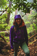 © Michael - Female tourist in a hard-shell rain jacket walks up a misty jungle trail in the rain. Poco dos Pulgas waterfalls, Madeira Island, Portugal, Europe.